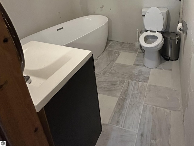 bathroom with toilet, a bathing tub, and vanity