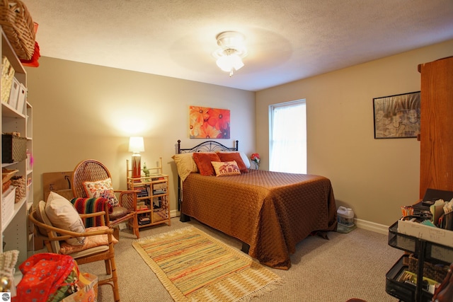 bedroom featuring a textured ceiling, ceiling fan, and carpet