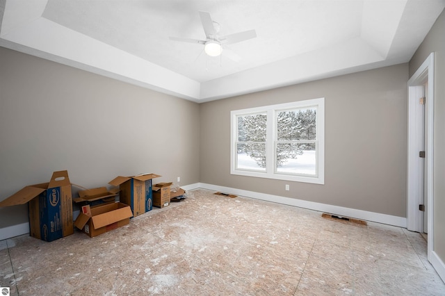 unfurnished room featuring ceiling fan and a tray ceiling