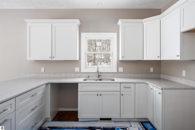 kitchen featuring white cabinetry and sink