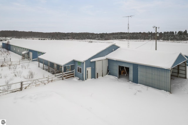 snow covered house featuring an outdoor structure