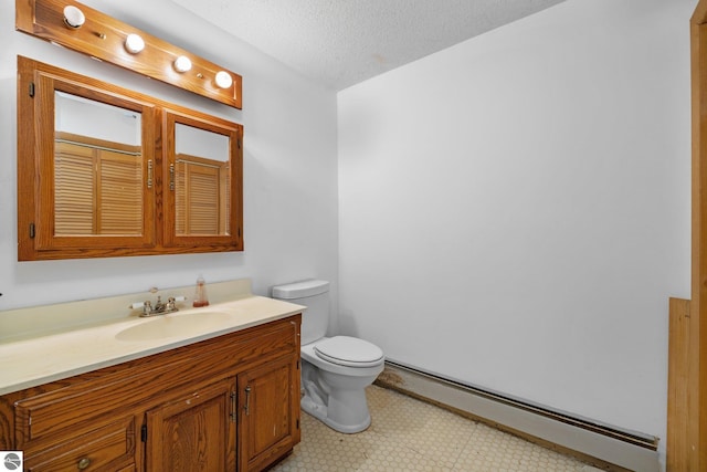 bathroom featuring toilet, vanity, baseboard heating, and a textured ceiling