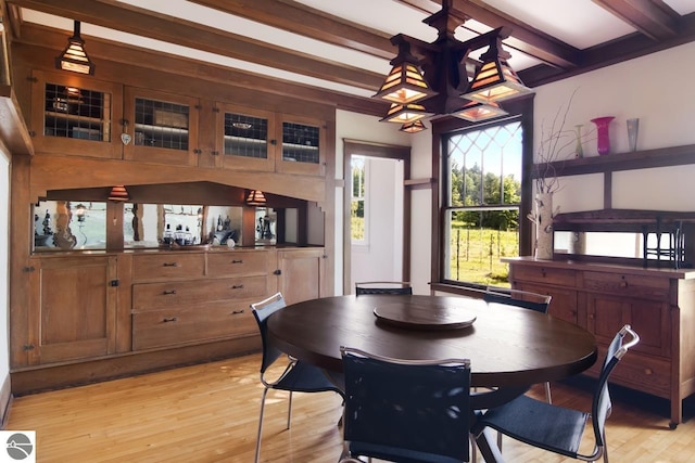 dining space with beamed ceiling and light wood-type flooring