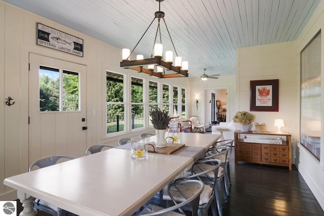 dining area featuring wood ceiling, ceiling fan with notable chandelier, wooden walls, and dark hardwood / wood-style floors