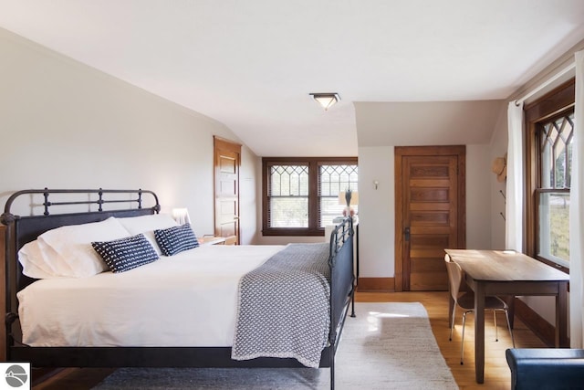 bedroom featuring vaulted ceiling and light hardwood / wood-style flooring