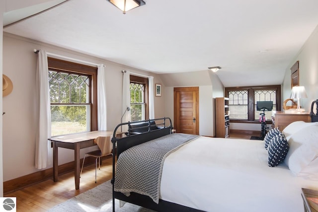 bedroom featuring light hardwood / wood-style floors and vaulted ceiling