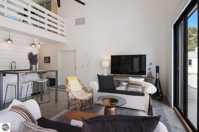 living room featuring concrete flooring and a towering ceiling