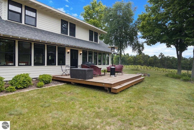 rear view of house featuring a yard and a wooden deck