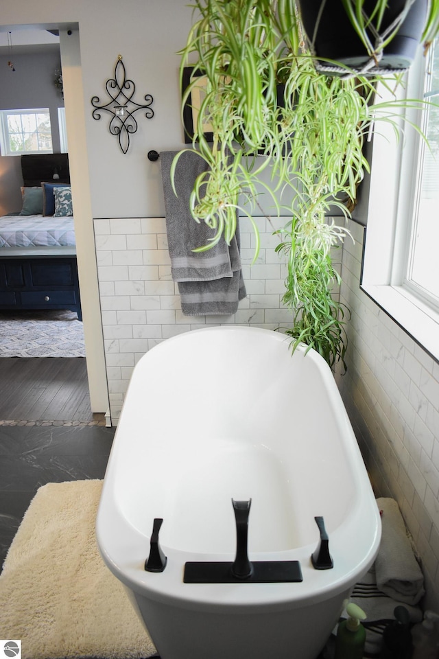 bathroom with plenty of natural light and a bath