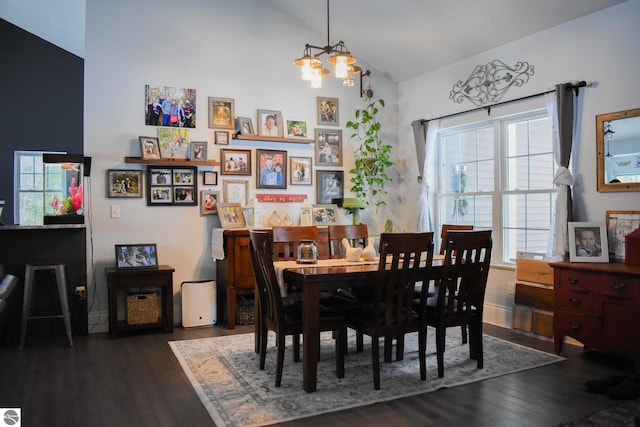 dining area with a healthy amount of sunlight, vaulted ceiling, dark hardwood / wood-style floors, and a notable chandelier