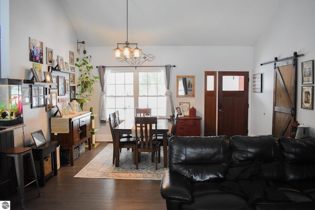 living room with lofted ceiling, a barn door, dark hardwood / wood-style floors, and a notable chandelier