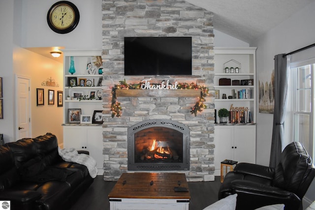 living room with a textured ceiling, lofted ceiling, built in features, and a stone fireplace