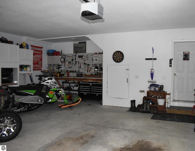 garage featuring a garage door opener and a workshop area