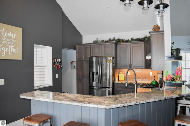 kitchen with kitchen peninsula and stainless steel refrigerator with ice dispenser