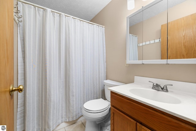 bathroom featuring a textured ceiling, tile patterned floors, vanity, and toilet