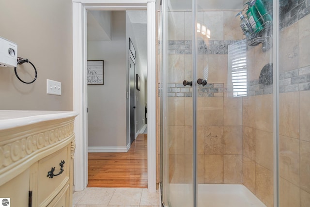 bathroom with tile patterned floors and a shower with door