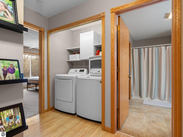 laundry room with light hardwood / wood-style floors and washer and dryer