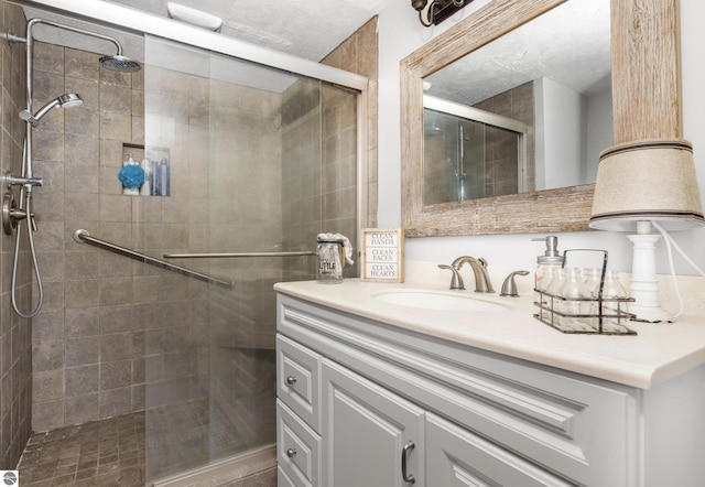 bathroom with a shower with shower door and vanity