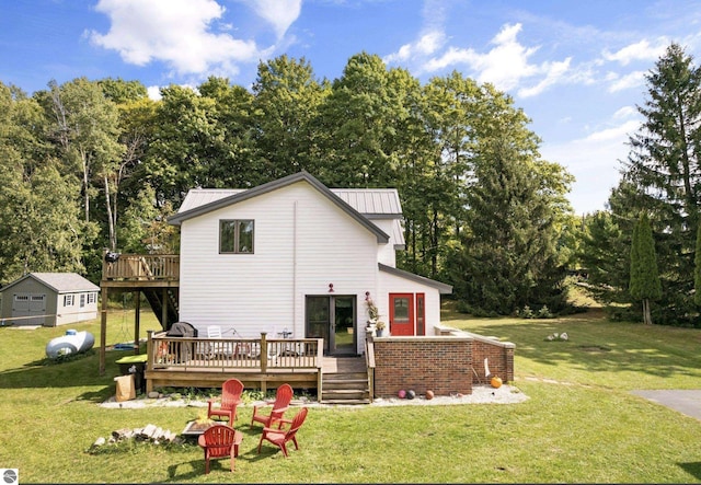 rear view of property featuring a wooden deck and a yard