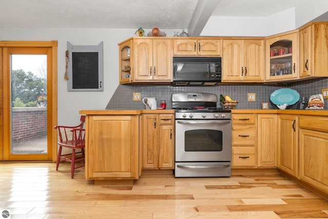 kitchen with stainless steel gas stove, light brown cabinetry, a textured ceiling, light hardwood / wood-style floors, and decorative backsplash