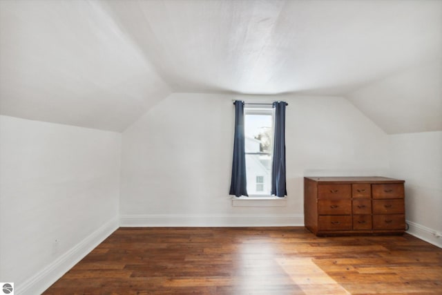 additional living space featuring vaulted ceiling and hardwood / wood-style floors