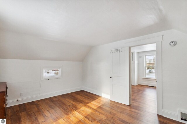 additional living space featuring hardwood / wood-style floors and lofted ceiling