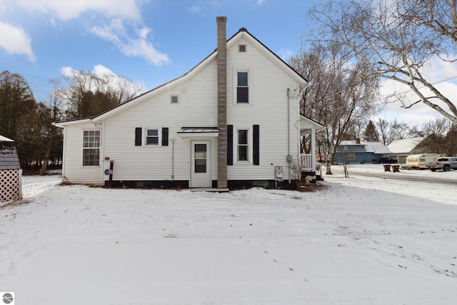 view of snow covered back of property