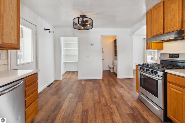 kitchen with stainless steel appliances, crown molding, and dark hardwood / wood-style floors