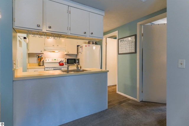 kitchen with sink, dark colored carpet, white appliances, and white cabinetry