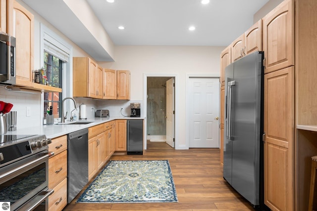 kitchen featuring light brown cabinets, wine cooler, high quality appliances, sink, and hardwood / wood-style flooring