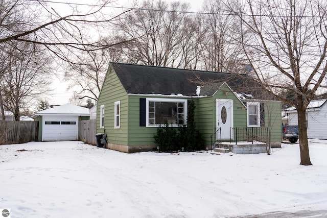 bungalow-style house with a garage and an outbuilding