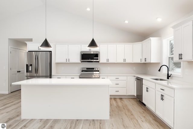 kitchen featuring pendant lighting, a center island, appliances with stainless steel finishes, and sink