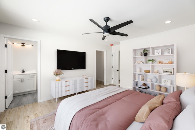 bedroom with ceiling fan, ensuite bathroom, and light hardwood / wood-style flooring