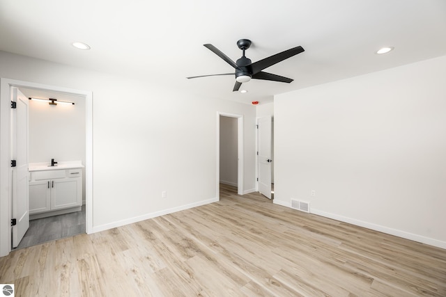 unfurnished bedroom featuring ceiling fan, light hardwood / wood-style floors, ensuite bathroom, and sink