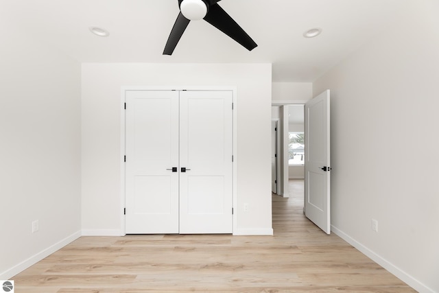 unfurnished bedroom featuring light hardwood / wood-style floors, a closet, and ceiling fan