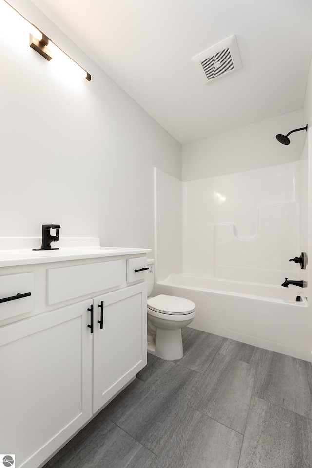 full bathroom with toilet, vanity, and shower / washtub combination