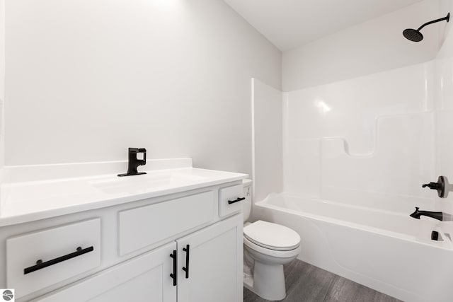 full bathroom featuring shower / bathtub combination, hardwood / wood-style flooring, toilet, and vanity