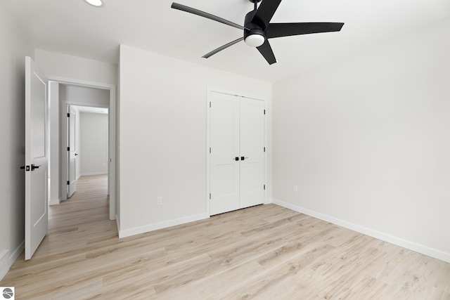 unfurnished bedroom featuring light wood-type flooring, ceiling fan, and a closet