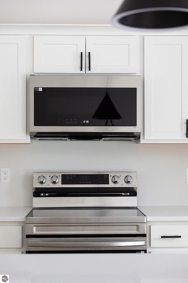 interior details featuring white cabinets and appliances with stainless steel finishes