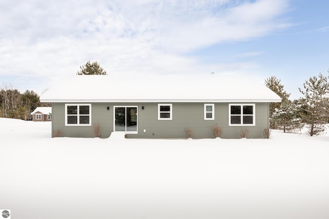 view of snow covered back of property