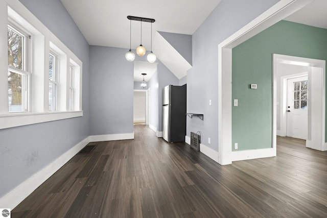 unfurnished dining area featuring dark wood-type flooring and lofted ceiling