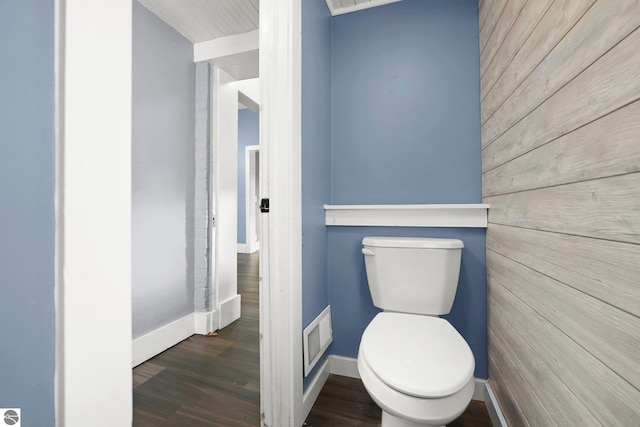 bathroom featuring hardwood / wood-style floors, toilet, and wood walls