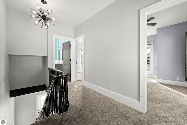 hallway featuring a notable chandelier and carpet