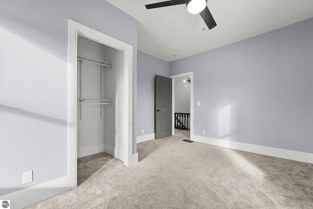 unfurnished bedroom with a closet, ceiling fan, and light carpet