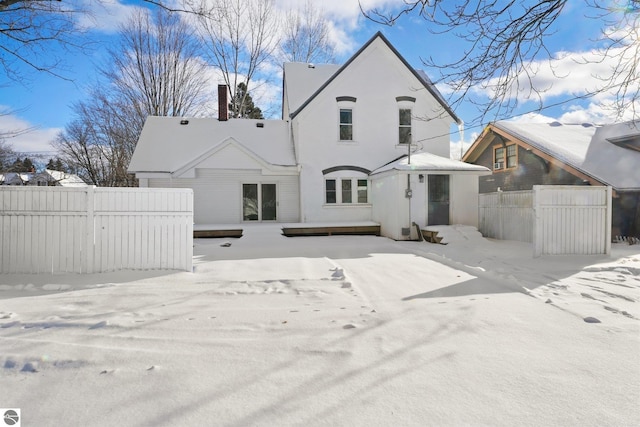 view of snow covered back of property