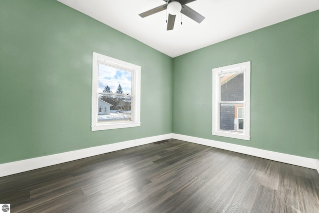 empty room with ceiling fan and dark hardwood / wood-style flooring