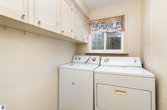 washroom with cabinets and washing machine and dryer