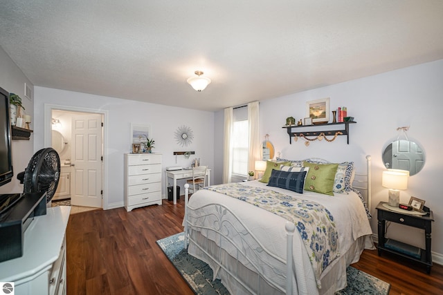 bedroom with a textured ceiling and dark hardwood / wood-style flooring