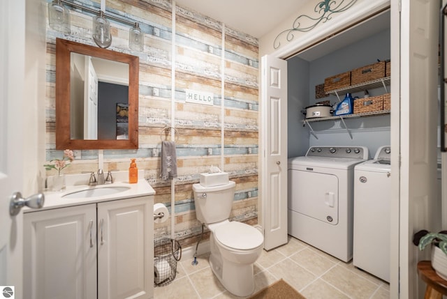 bathroom with washing machine and dryer, toilet, vanity, and tile patterned flooring