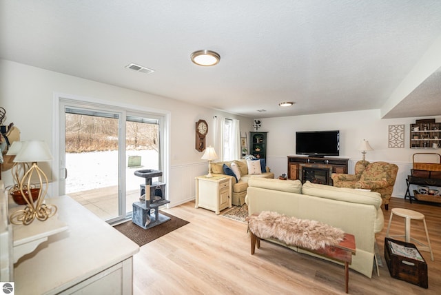 living room featuring light hardwood / wood-style flooring and a textured ceiling